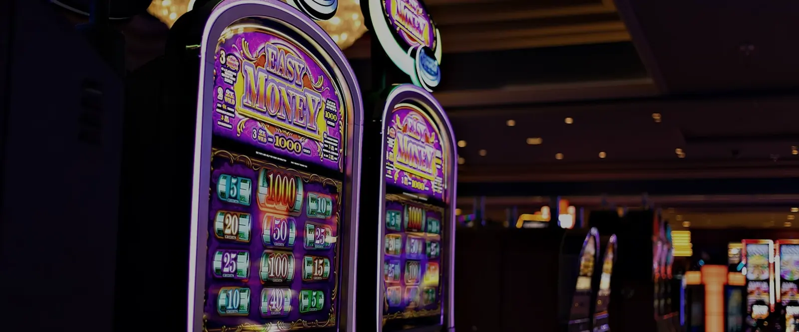 Rows of slot machines on a darkened casino floor